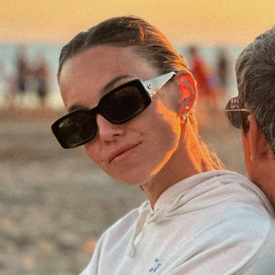 Sophia Laura, cantante de Tachame La Doble, con anteojos de sol en la playa al atardecer